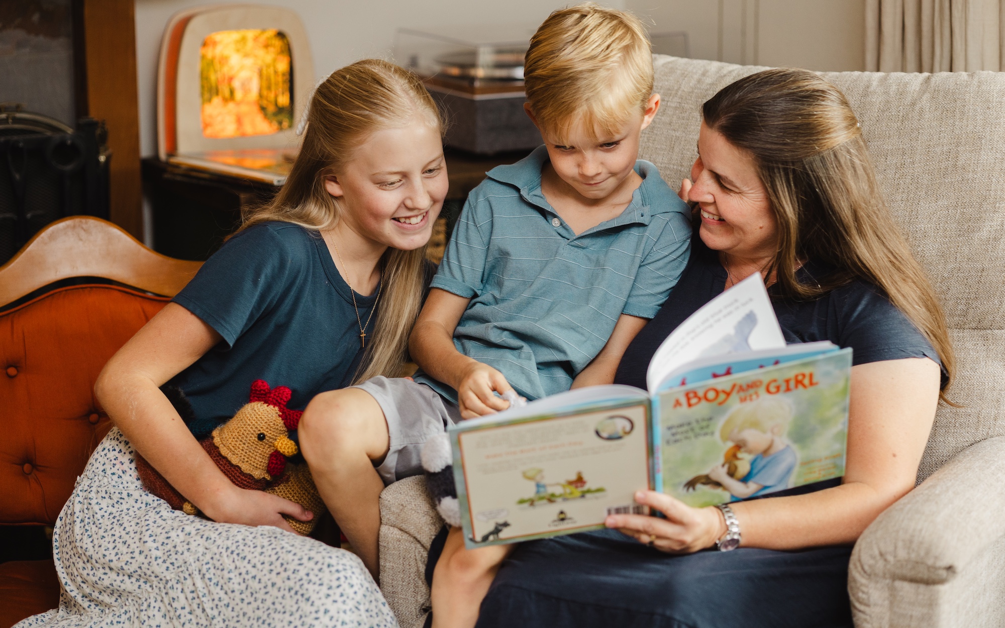 A mother reading A Boy and His Girl with two children